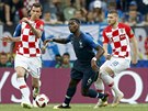 Francouzský záloník Paul Pogba prochází mezi dvojicí Chorvat - vlevo Mario...