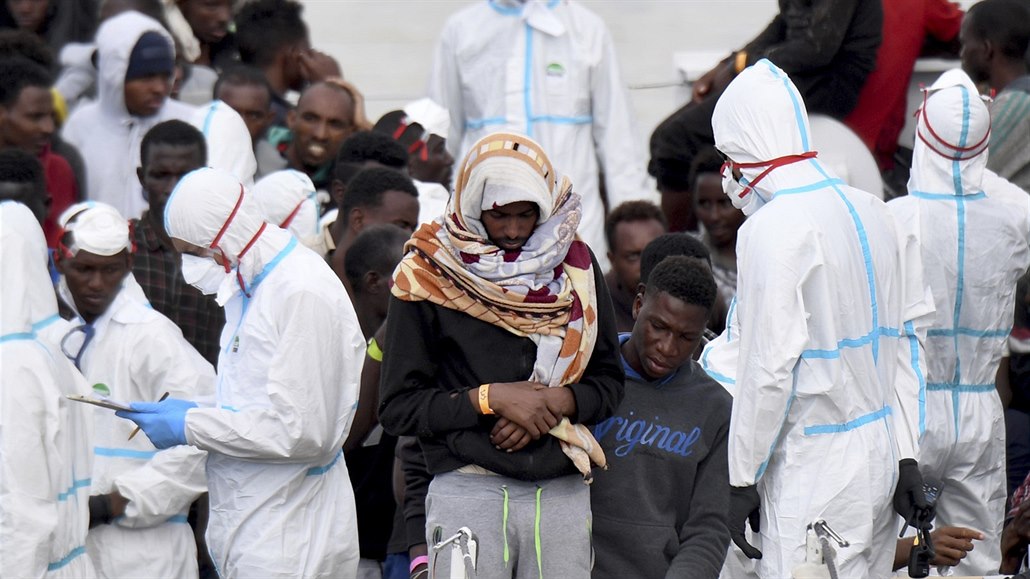 Migranti čekají na vylodění z lodi italské pobřežní stráže Diciotti.