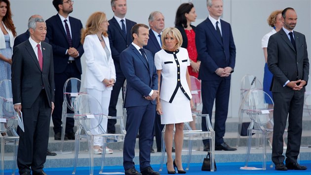 Prezident Emmanuel Macron sleduje společně se svou ženou a singapurským premiérem Lee Hsien Loongem vojenskou přehlídku u příležitosti oslav Dne Bastily. (14. července 2018)
