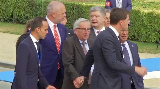 Předsedu Evropské komise Jeana-Clauda Junckera (v brýlích) museli před galavečeří na summitu NATO v Bruselu při chůzi podpírat ostatní státníci. (11. července 2018)