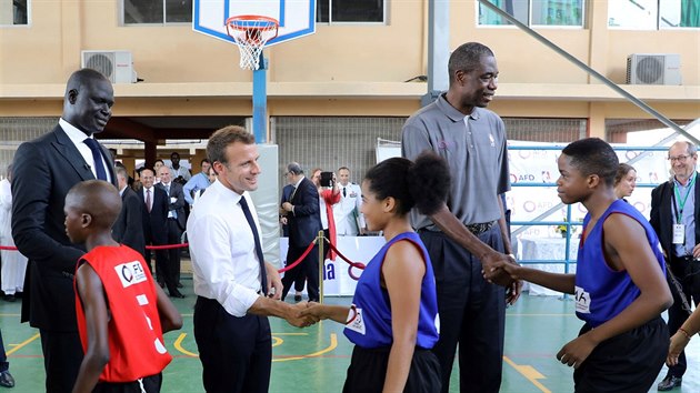 Amadou Gallo Fall (vlevo), viceprezident NBA pro Afriku, francouzsk prezident Emmanuel Macron a legendrn basketbalista Dikembe Mutombo (zleva) podvaj ruce malm astnkm turnaje v Lagosu.