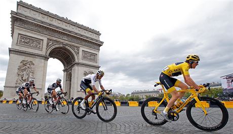 Britsk jezdec Geraint Thomas (ve lutm) projd jako vtz Tour de France v...