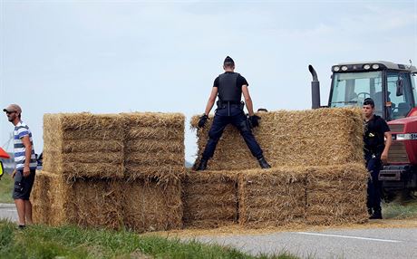 Policist se sna odklidit balky slmy.