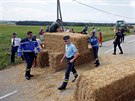 Policisté se snaí odklidit balíky slámy, kterými farmái zatarasili cestu 16....