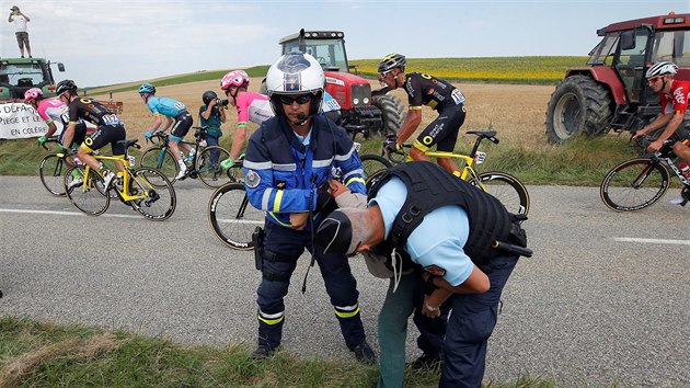 Policist se sna zpacifikovat jednoho z protestujcch farm bhem 16. etapy Tour.