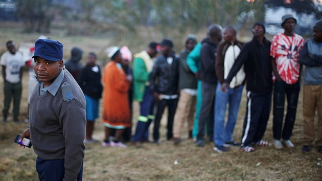 Příslušník polici hlídá voliče ve frontě, Zimbabwe (30. 7. 2018).