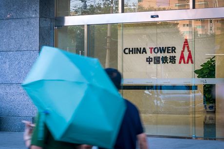 Lidé procházející kolem centrály spolenosti China Tower v Pekingu.