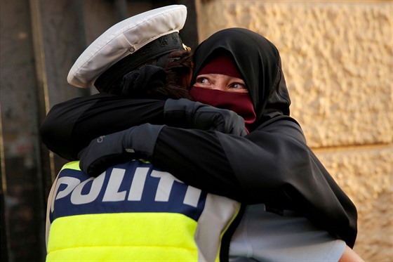 Muslimka Ayah se objímá s policistkou bhem demonstrace proti zákazu zahalování...