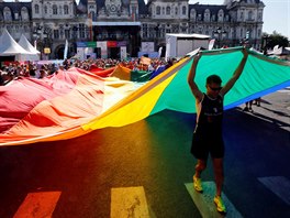 Lidé na zahájení desátého roníku Gay Games zdvihají nad hlavu duhovou vlajku...