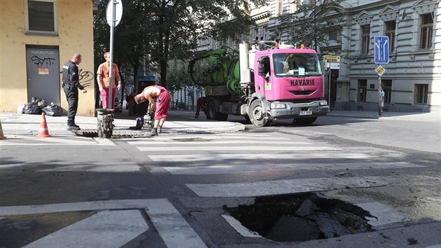 U kiovatky Mnesovy a Italsk ulice v Praze se pod vozidlem technickch slueb propadla vozovka. (2. srpna 2018)