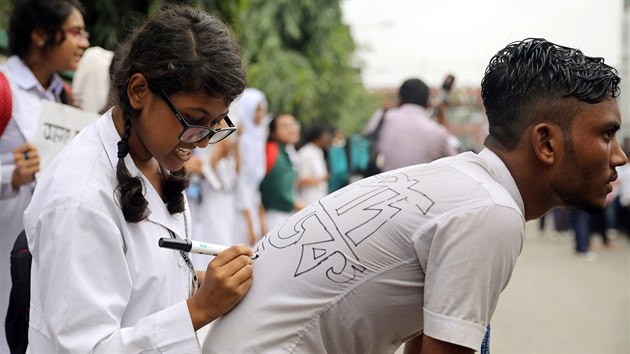 Banglad隚t studenti se navzjem popisuj slogany pro protesty za bezpenj dopravu