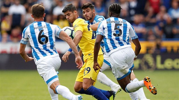 Álvaro Morata z Chelsea (ve žlutém) se snaží uprchnout trojici protihráčů z Huddersfieldu.
