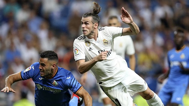 Bruno Cabrera (Getafe) a Gareth Bale (Real Madrid) padají po vzájemném souboji.
