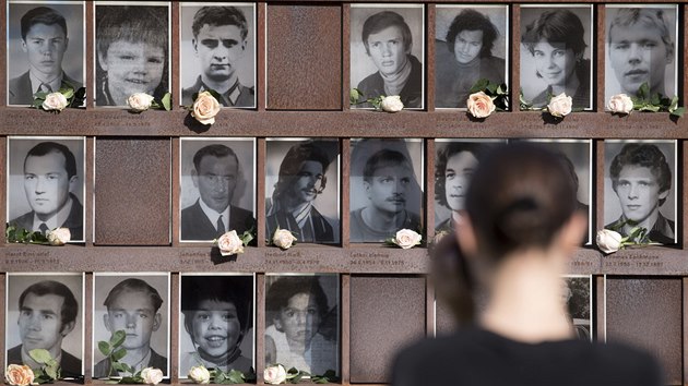 Návštěvnice Památníku Berlínské zdi v Berlíně před fotkami obětí východoněmeckého režimu (13.8.2018)