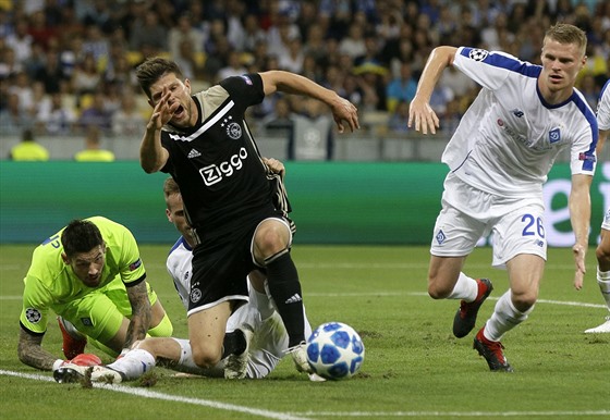 Klaas Jan Huntelaar z Ajaxu padá ve vápn Dynama Kyjev. Vpravo je Mykyta Burda