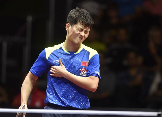 Čínský stolní tenista Čeng Pchej-feng si s bolestivou grimasou svírá zraněný prsní sval během finále Czech Open.
