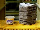 A container of 500gr of margarine is pictured next to 3,000,000 bolivars, its...