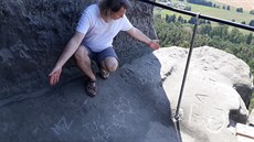 Petr Jenč ukazuje rytiny, které poškodily přímo skalní hrad Drábské světničky....