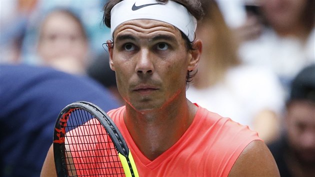 HRA NA STRUNY. panlsk tenista Rafael Nadal si rovn struny na sv raket ve tetm kole US Open.