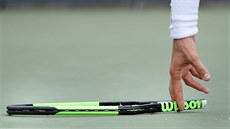 TROSKY.  Argentinský tenista Guido Pella sbírá zbytek své rakety, kterou...