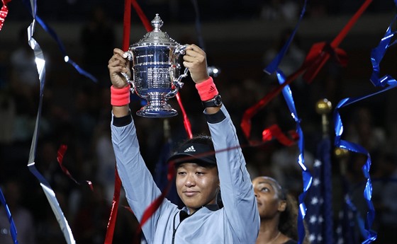 Japonka Naomi Ósakaová s rozpaitým výrazem pózuje s trofejí pro ampionku US...