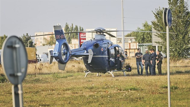 Policejní vrtulník na místě tragického pádu malého vrtulníku do prázdné haly v průmyslové zóně plzeňských Borských Polí.