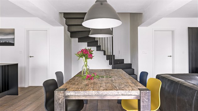 Kuchyňská sestava nábytku (Indeco) je vyrobena danému prostoru na míru. Masivní dřevěný stůl je vtipně doplněn plastovými židlemi v odlišných barvách.