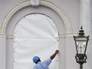 Pracovník zabeduje okno radnice v americkém Charlestonu (v Západní Virgínii)...