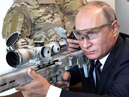 Ruský prezident Vladimir Putin se dívá do míidla odstelovací puky na zbrojní...