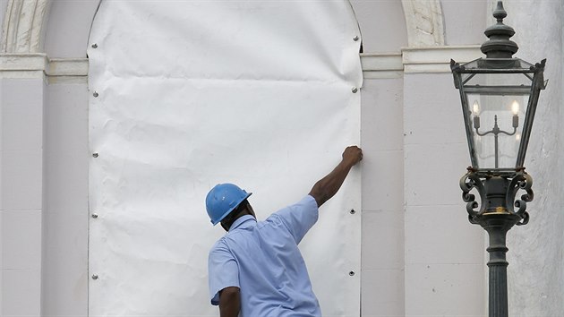 Pracovnk zabeduje okno radnice v americkm Charlestonu (v Zpadn Virgnii) ped pchodem huriknu Florence (11. z 2018) (AP Photo/Mic Smith)