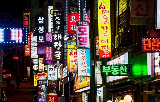 Rozsvícené cedule obchod a restaurací v centru Soulu.