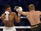 British boxer Anthony Joshua, left, his nose bleeding, fights Russian boxer...