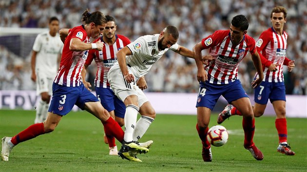 tonk Realu Madrid Karim Benzema v souboji s hri Atltica Madrid Filipem Luisem a Rodrigem.