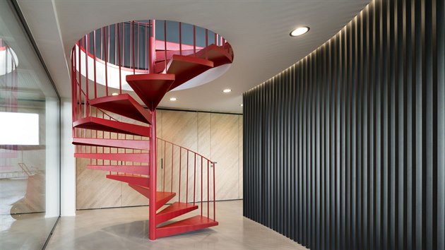 Červené ocelové schodiště podtrhuje industriální charakter objektu.