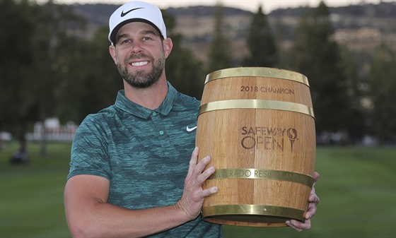 Americký golfista Kevin Tway s trofejí pro vítze.