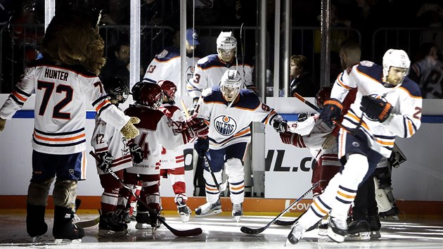 Hokejist Edmontonu naskakuj na led nmeckho tmu Klner Haie.