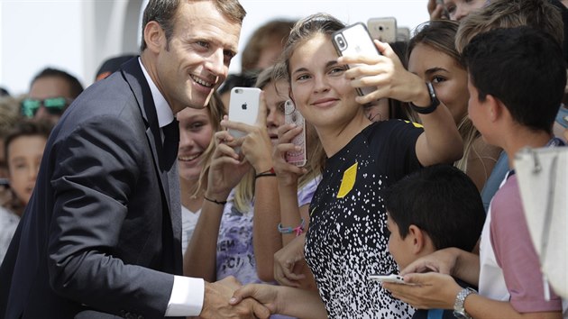 Francouzsk prezident Emmanuel Macron pzuje s mladmi k selfku na francouzskm ostrov Svat Bartoloml v Karibiku, kter ped rokem stihla iveln pohroma (30. z 2018).
