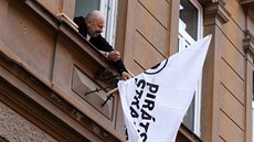 Ladislav Tkaczyszyn vyvěšuje vlajku na domě, v jehož dvoře si Piráti zřídili...