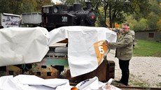 Michael Rund, ředitel sokolovského muzea, zakrývá důlní lokomotivu...