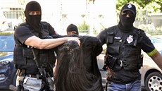 Maskovaní policisté vedou Alenu Zsuzsovou k trestnímu soudu v Banské Bystrici....