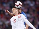 Piotr Zielinski z Polska hlavikuje v utkání s Itálií.