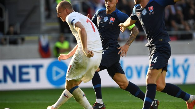 Michael Krmenčík (v bílém) uniká dvojici bránících protihráčů a v utkání Ligy národů překonává slovenskou obranu.