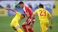 Srb Nemanja Radonjič vede míč v utkání Ligy národů proti Rumunsku. Vpředu ho...