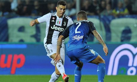 Cristiano Ronaldo z Juventusu klikuje s míem ped Giovannim Di Lorenzem z...