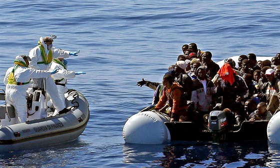 Italští policisté se blíží ke člunu s africkými uprchlíky nedaleko libyjského...