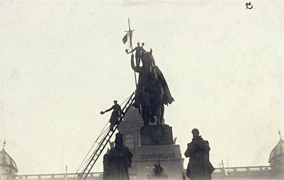 Lidé upevují eskou vlajku na kopí sochy sv. Václava na Václavském námstí....