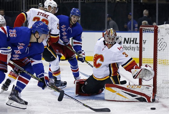 David Rittich hájí branku Calgary pi pokusu Jimmyho Veseyho z New York Rangers.