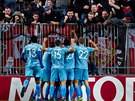 Fotbalisté Slavie se radují z gólu ped kotlem svých fanouk.