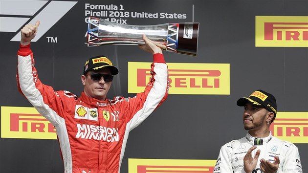 Kimi Rikknen zved trofej pro vtze Velk ceny USA. Tlesk mu Lewis Hamilton.