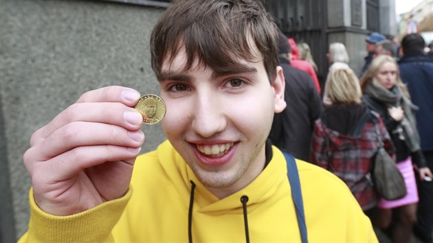 Mladý muž ukazuje čerstvě získanou dvacetikorunovou minci, kterou ČNB vydala ke stoletému výročí samostatného Československa. (24. října 2018)